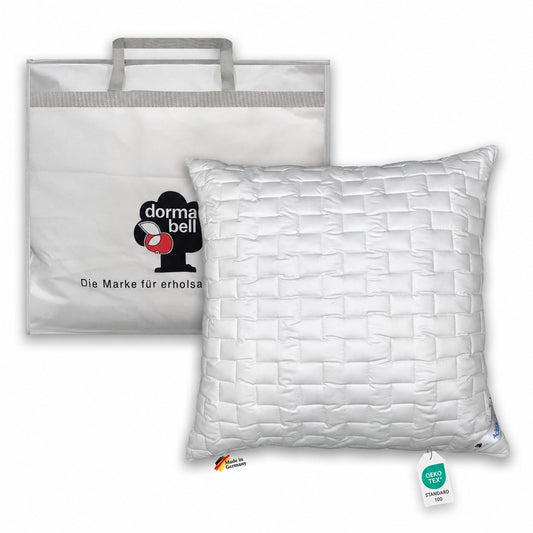 Weißes Kopfkissen 80x80 cm dormabell Active fresh mit rechteckiger Steppung, aufrecht vor einer Tragetasche.