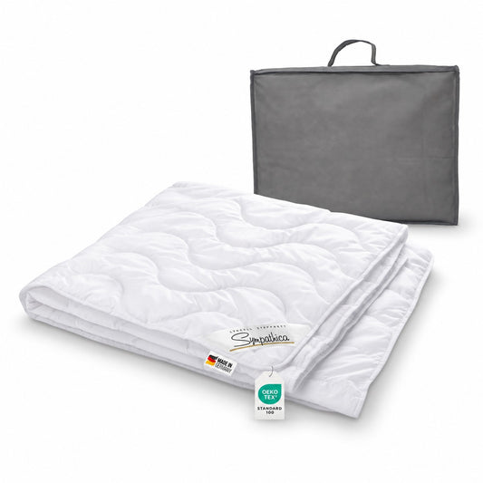 Weiße Garanta Sommerbettdecke 200x200 cm aus 100 % Lyocell, gefaltet mit Wellensteppung und grauer Tragetasche.          